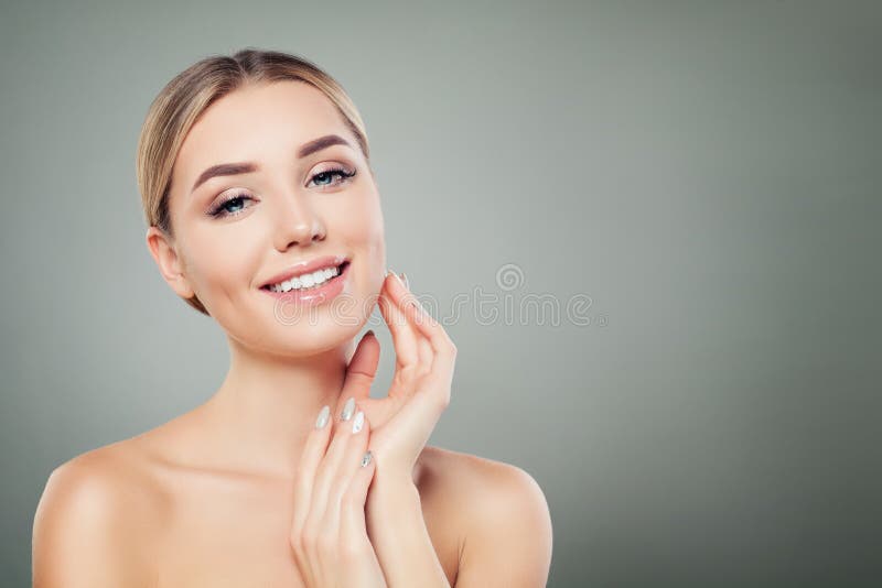 Beautiful woman smiling and touching her hand her face. Cute girl with clear skin. Facial treatment, face lifting and cosmetology concept. Beautiful woman smiling and touching her hand her face. Cute girl with clear skin. Facial treatment, face lifting and cosmetology concept.